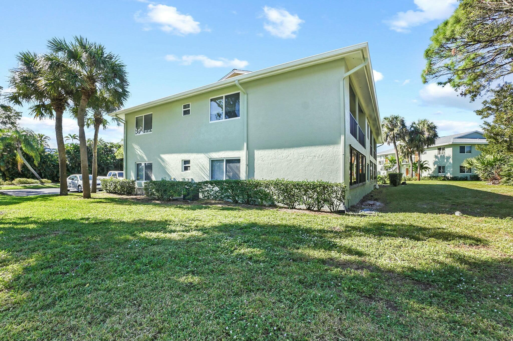 983 Northwest Spruce Ridge Drive, Unit 4 Stuart, FL 34994 - Photo 49 of 56 a front view of house with yard and trees