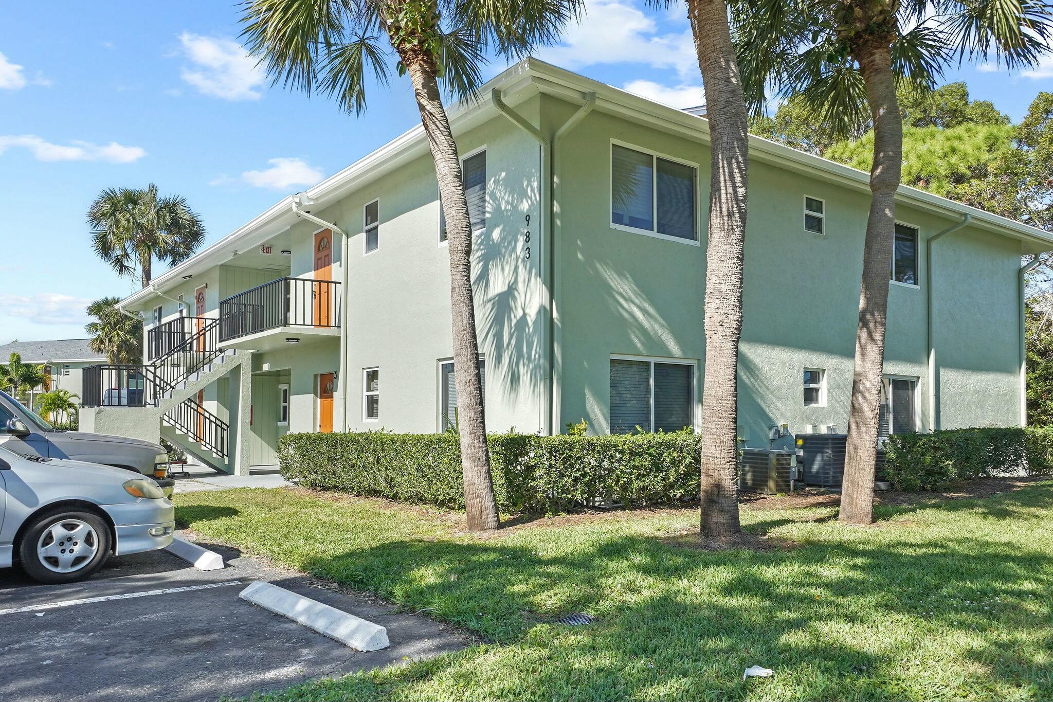 983 Northwest Spruce Ridge Drive, Unit 4 Stuart, FL 34994 - Photo 50 of 56 a view of a house with a yard and a car park