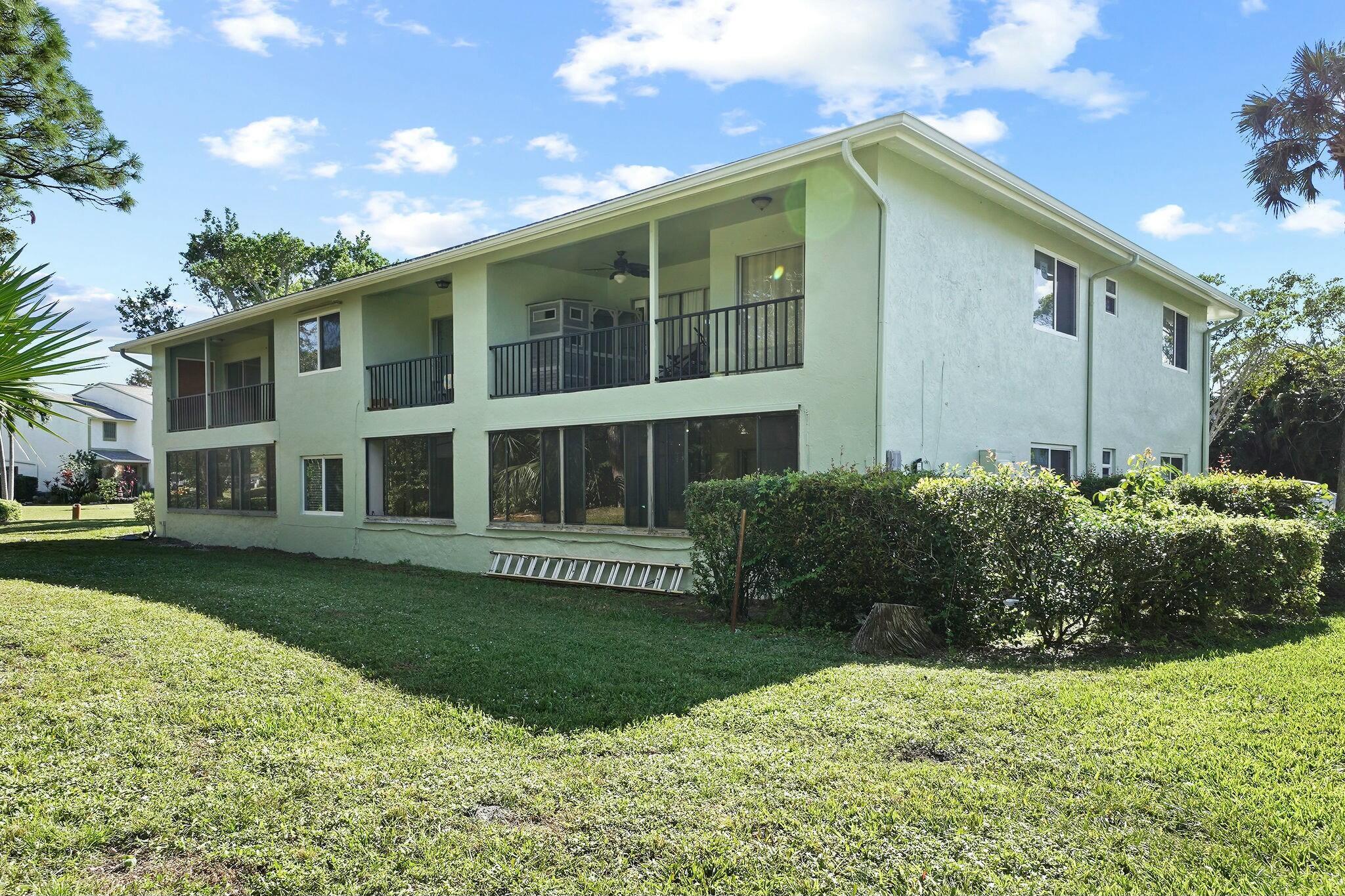 983 Northwest Spruce Ridge Drive, Unit 4 Stuart, FL 34994 - Photo 6 of 56 a front view of a house with a yard
