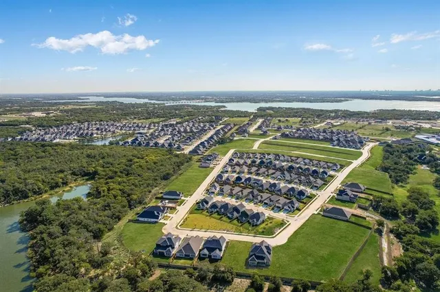 an aerial view of a residential building ocean and trees in the background