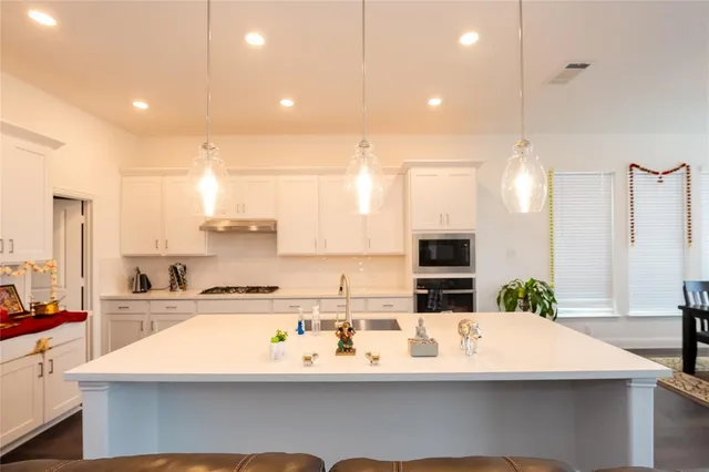 a kitchen with kitchen island stainless steel appliances a sink and a center island