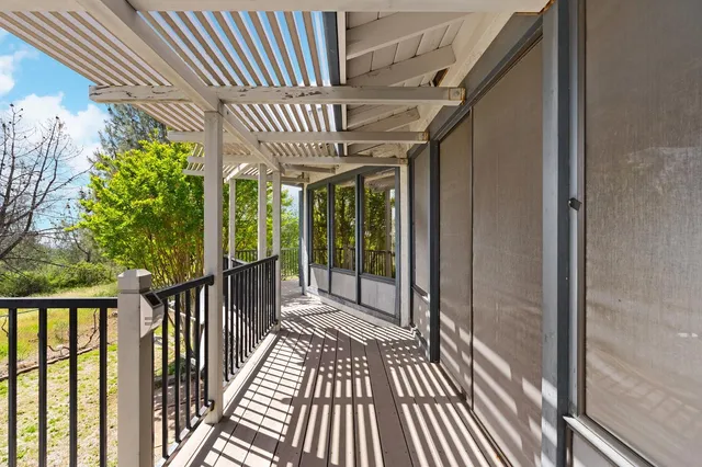 a view of a patio with table and chairs with wooden floor and fence