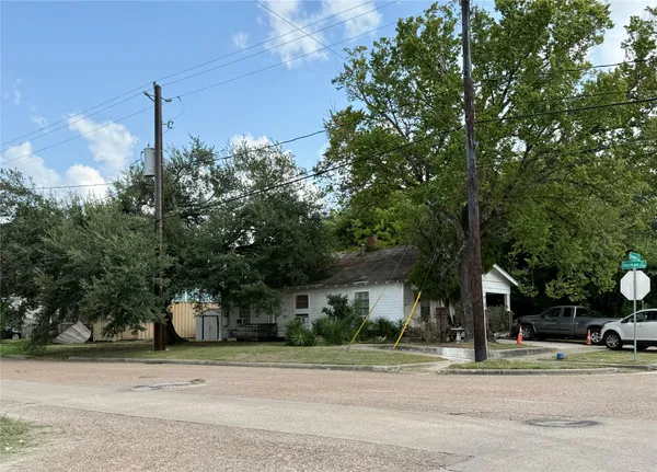 a yellow house with trees in front of it