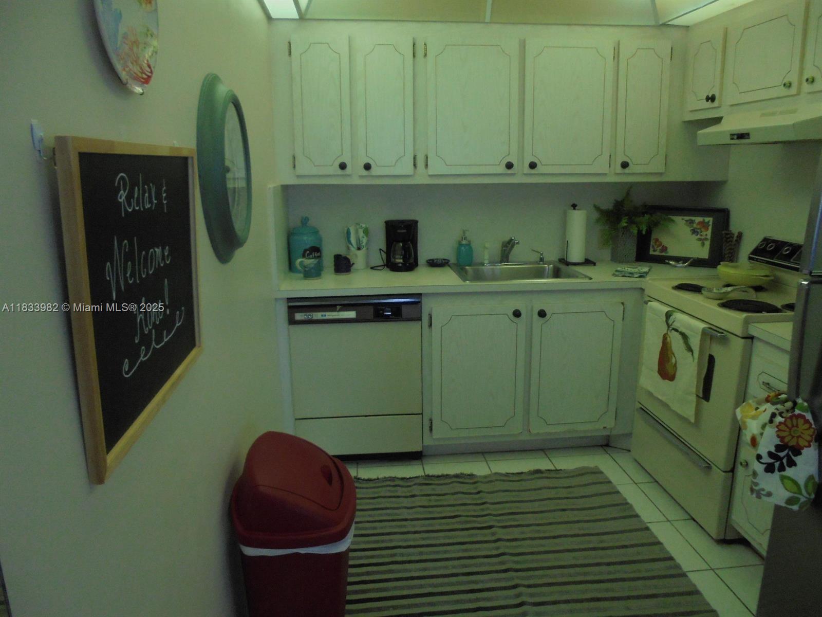 a kitchen with stainless steel appliances granite countertop a sink a refrigerator and a cabinets