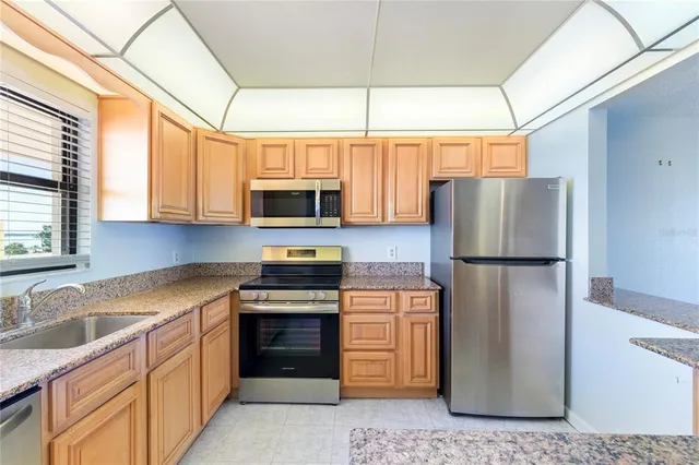 a kitchen with stainless steel appliances granite countertop a refrigerator stove and sink