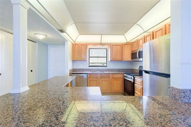 a kitchen with stainless steel appliances granite countertop a refrigerator stove and sink