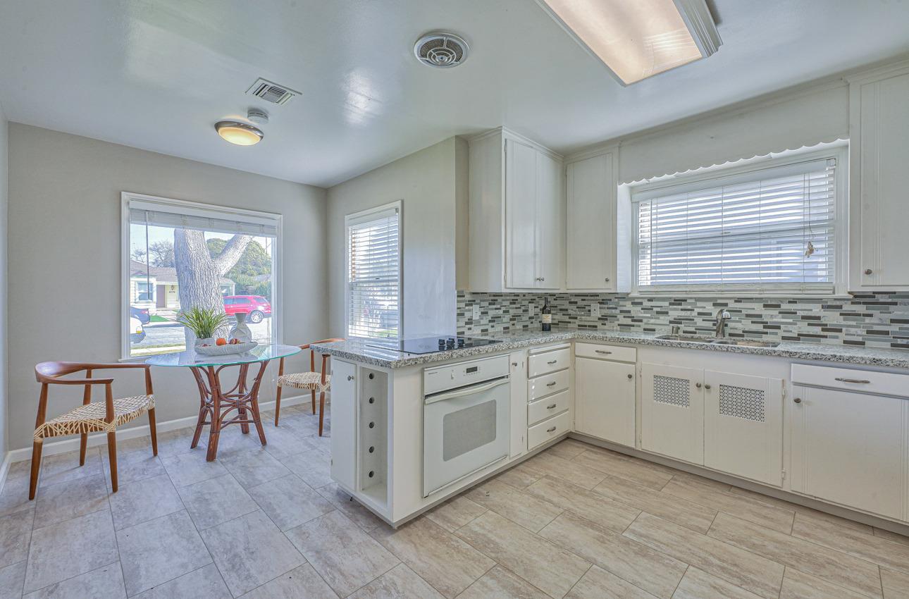 402 Lorimer Street Salinas, CA 93901 - Photo 13 of 36 a kitchen with stainless steel appliances granite countertop a stove a sink dishwasher a dining table and chairs with wooden floor