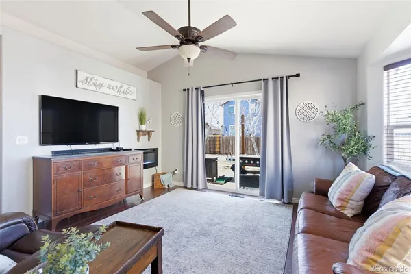 a kitchen with granite countertop a refrigerator a sink a stove top oven and wooden floor
