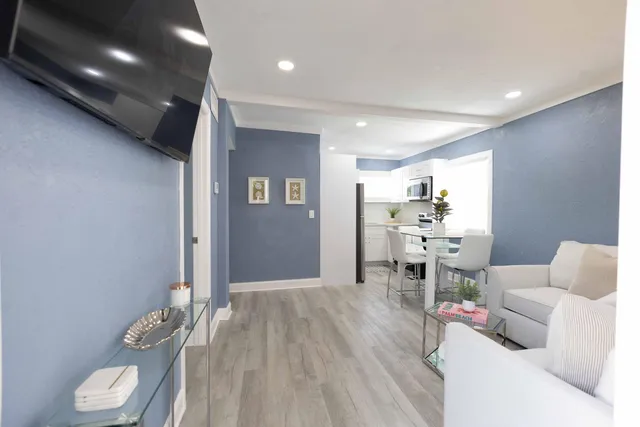 a living room with furniture and a wooden floor