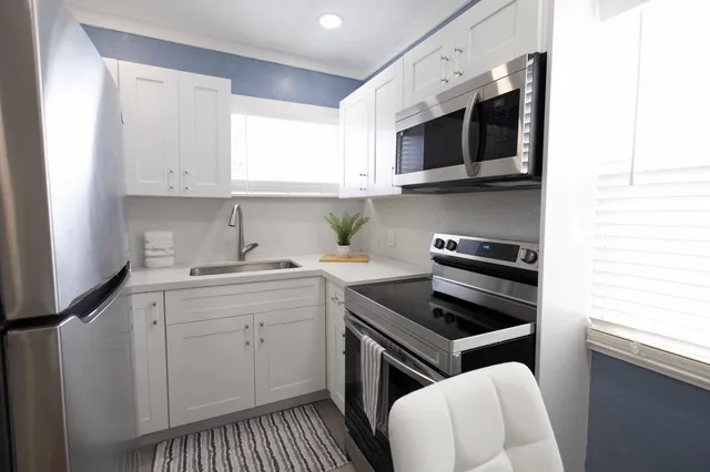a kitchen with stainless steel appliances a sink a stove and cabinets