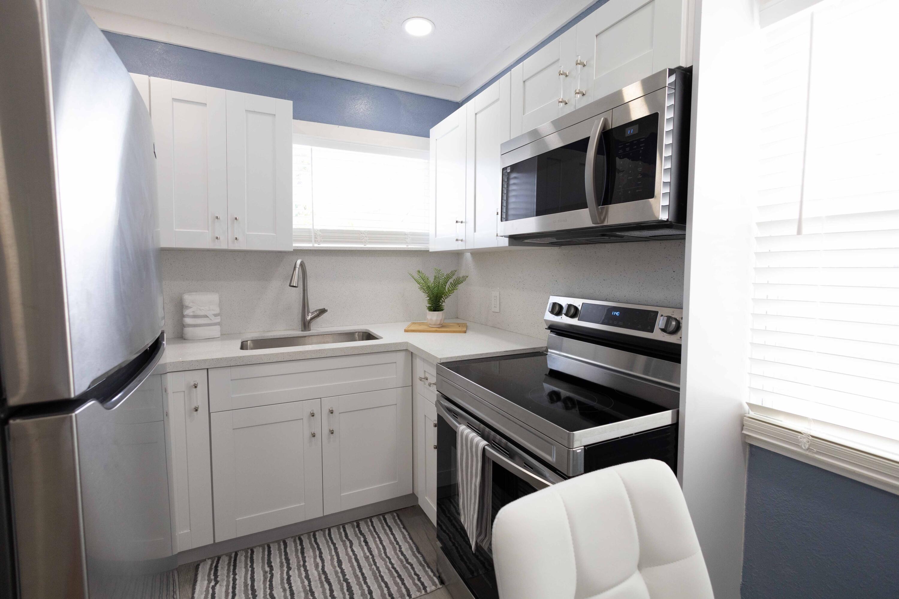 420 Avenida Alegre, Unit 4 West Palm Beach, FL 33405 - Photo 9 of 33 a kitchen with stainless steel appliances a sink a stove and cabinets