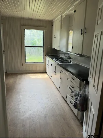 a large white kitchen with sink and window