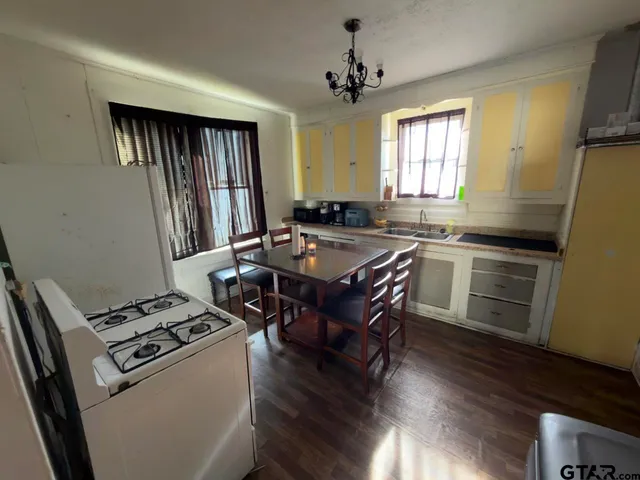 a kitchen with granite countertop a sink appliances a counter space and a window