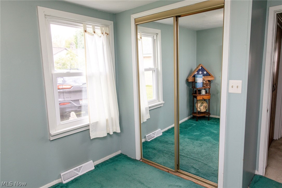 5467 Chapel Road Madison, OH 44057 - Photo 12 of 50 Mirrored sliding closet doors reflecting the room's green carpeting and light blue walls