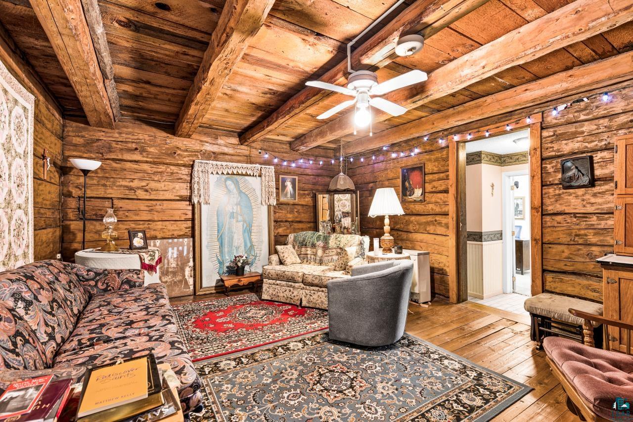 3723 Birchwood Road Kettle River, MN 55757 - Photo 24 of 48 Living room with hardwood / wood-style floors, a wooden ceiling with exposed beams, a ceiling fan, and log walls