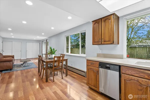 a kitchen with stainless steel appliances granite countertop a stove a sink a microwave dining table and chairs