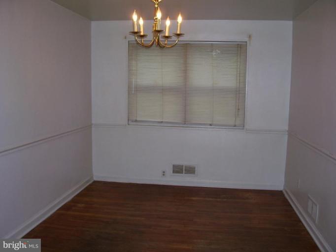 5464 Whitlock Road Baltimore, MD 21229 - Photo 3 of 6 an empty room with wooden floor