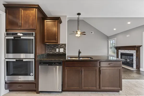 a kitchen with kitchen island granite countertop a stove oven and sink