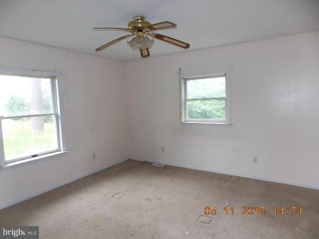 15745 Pratt Road Ridge, MD 20680 - Photo 8 of 12 an empty room with windows and fan