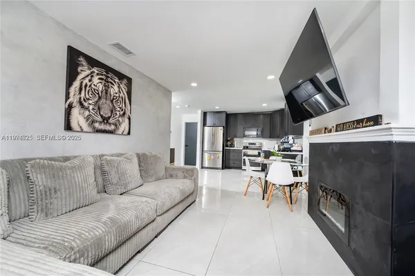 a living room with furniture and kitchen view