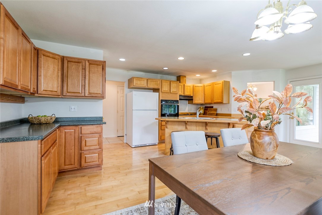 384 Sugar Hill Road Port Hadlock, WA 98339 - Photo 22 of 36 a kitchen with stainless steel appliances kitchen island granite countertop a refrigerator a stove a sink dishwasher with a dining table and chairs