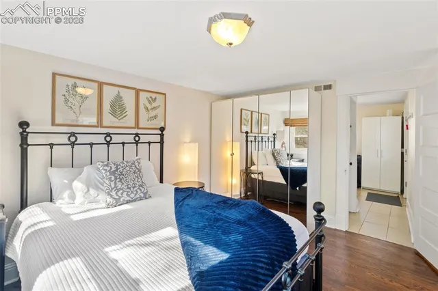 a bedroom with a bed and wooden floor