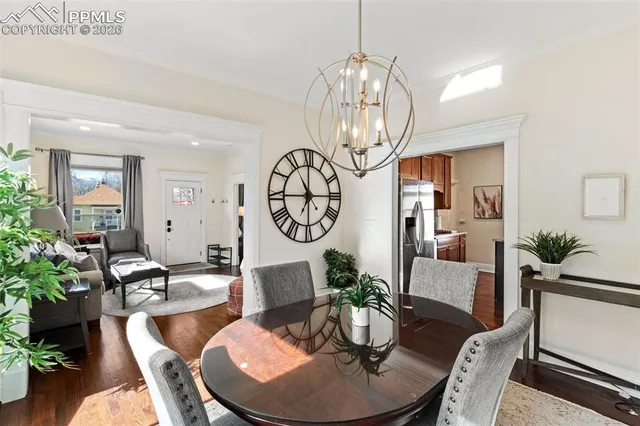 a living room with dining table and a chandelier