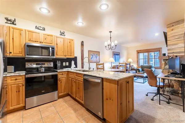 a kitchen with stainless steel appliances granite countertop a stove top oven a sink dishwasher and cabinets