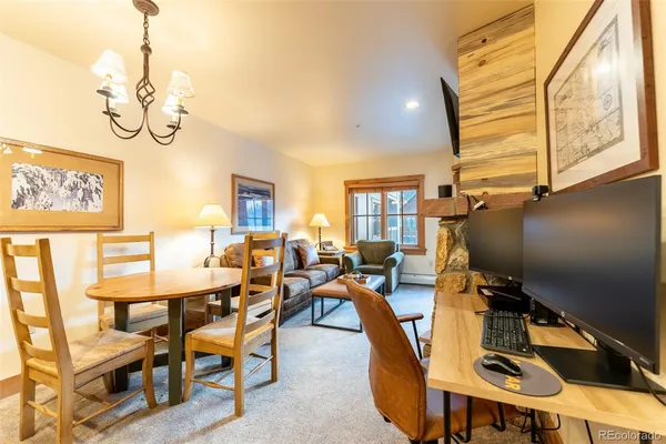 a view of a dining room with furniture a chandelier and wooden floor
