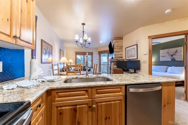 a view of living room and granite countertop kitchen