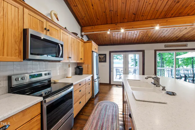 a dining hall with stainless steel appliances granite countertop a sink a stove and a refrigerator
