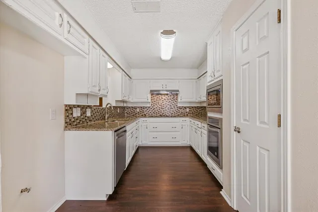 a kitchen with white cabinets and white appliances