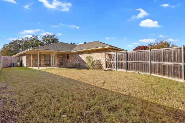 a view of a backyard with wooden fence