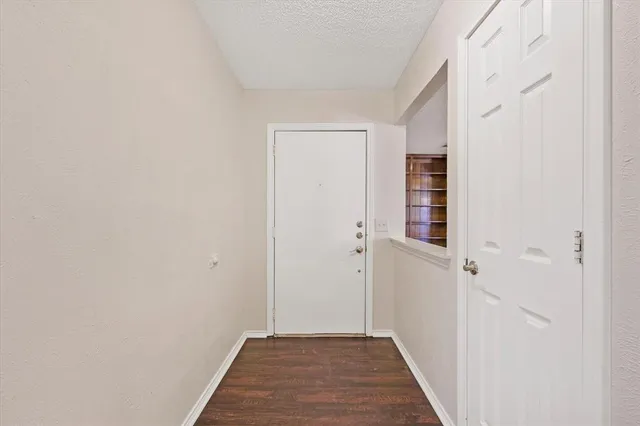 a view of a hallway with wooden floor and closet