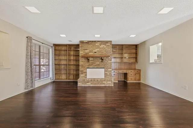 a view of empty room with wooden floor and windows