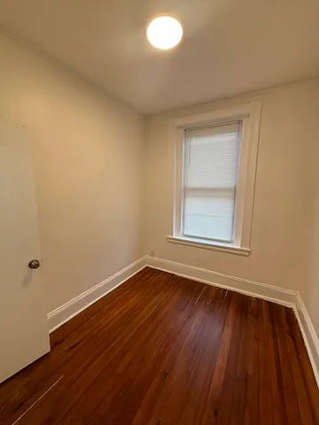 a view of an empty room with wooden and a window