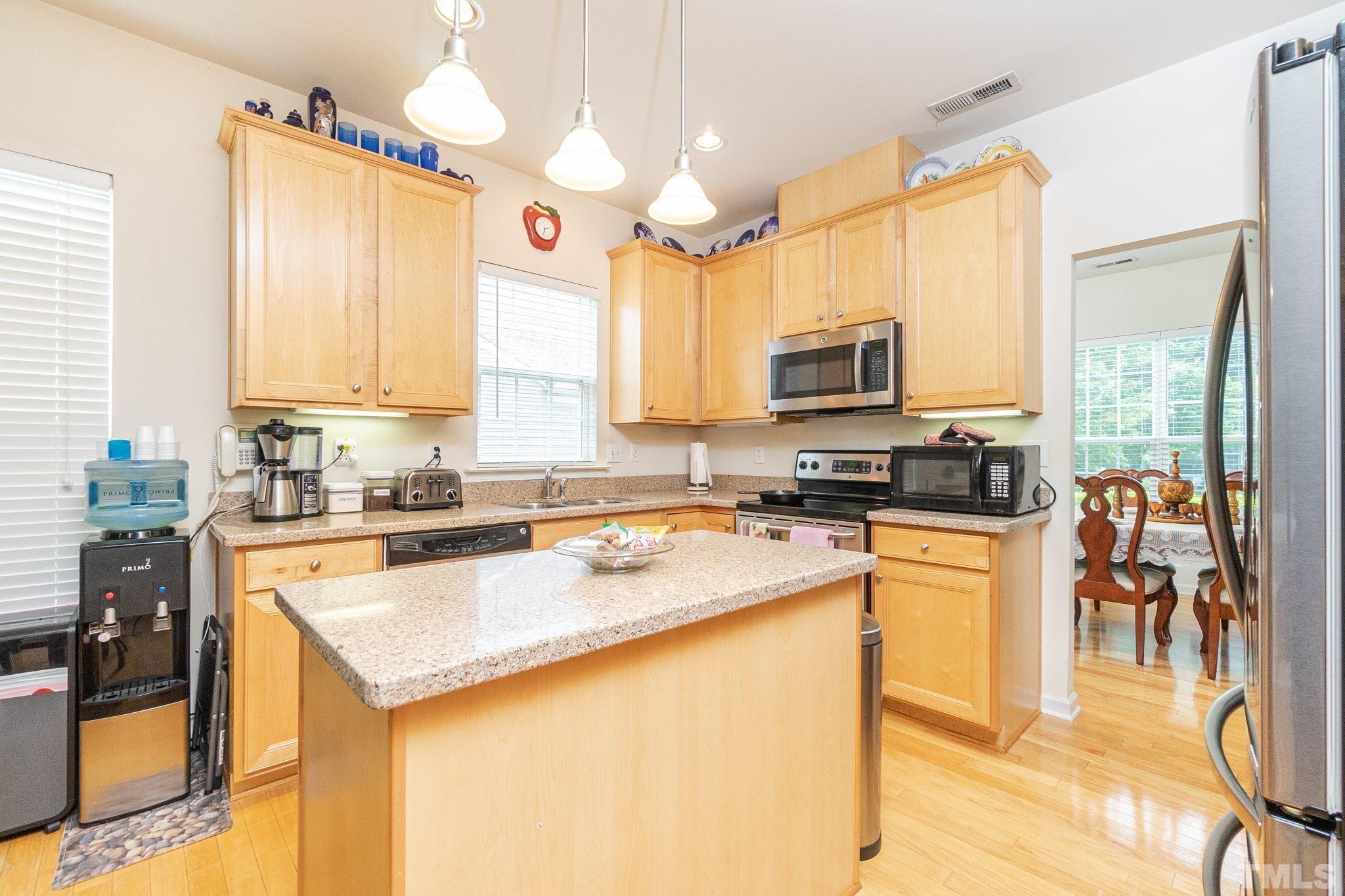 3404 Secretariat Way Raleigh, NC 27614 - Photo 13 of 44 a kitchen with stainless steel appliances a stove sink microwave and cabinets