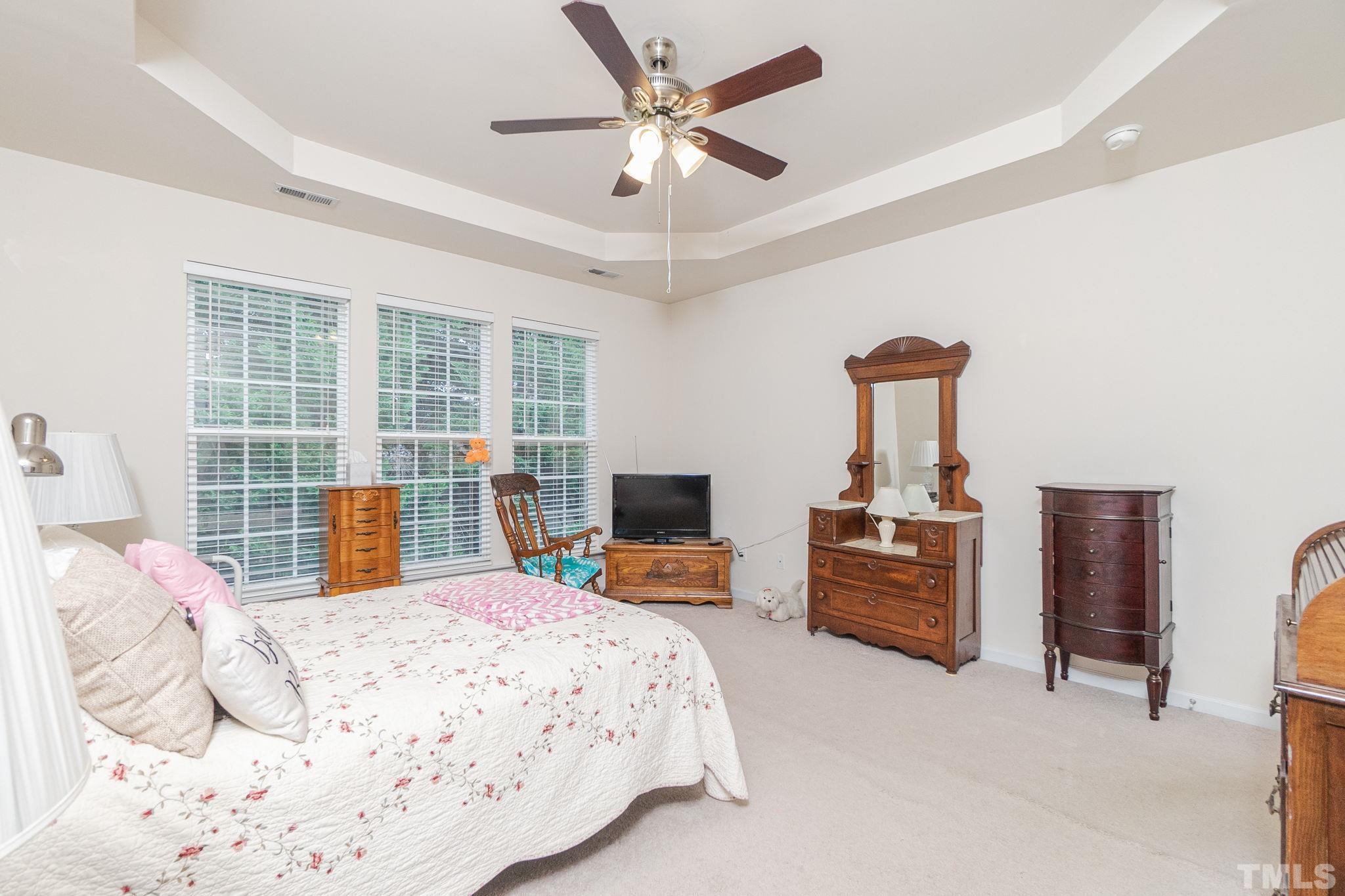 3404 Secretariat Way Raleigh, NC 27614 - Photo 26 of 44 a bedroom with a large bed and a chandelier