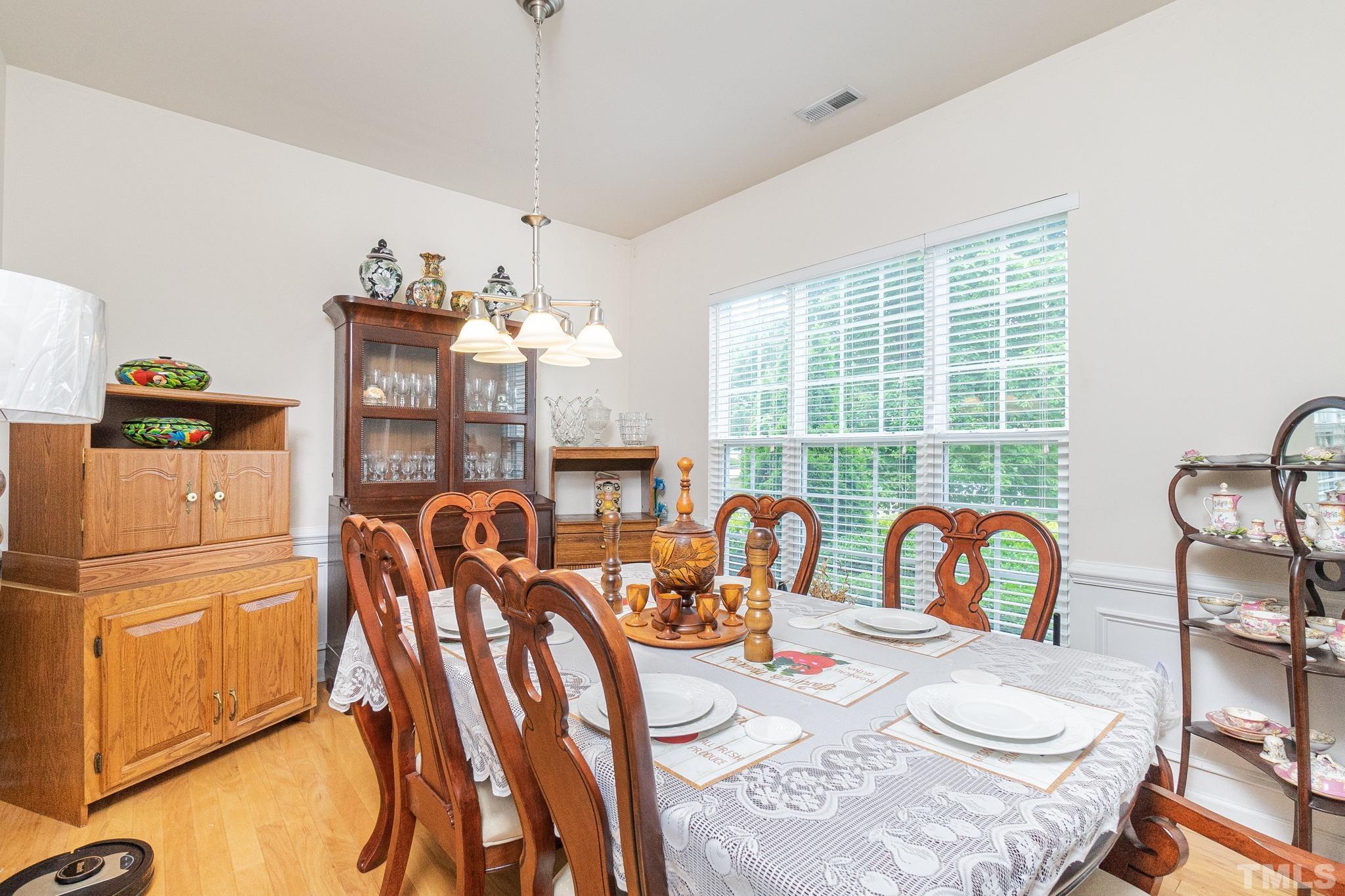 3404 Secretariat Way Raleigh, NC 27614 - Photo 6 of 44 a dining room with furniture a chandelier and wooden floor