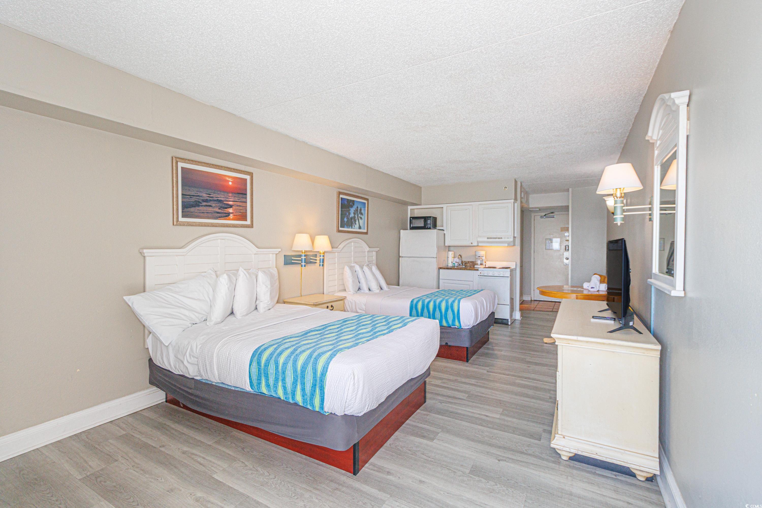 1207 South Ocean Boulevard, Unit 20703 Myrtle Beach, SC 29577 - Photo 7 of 22 Bedroom featuring a textured ceiling, white fridge, and light hardwood / wood-style flooring