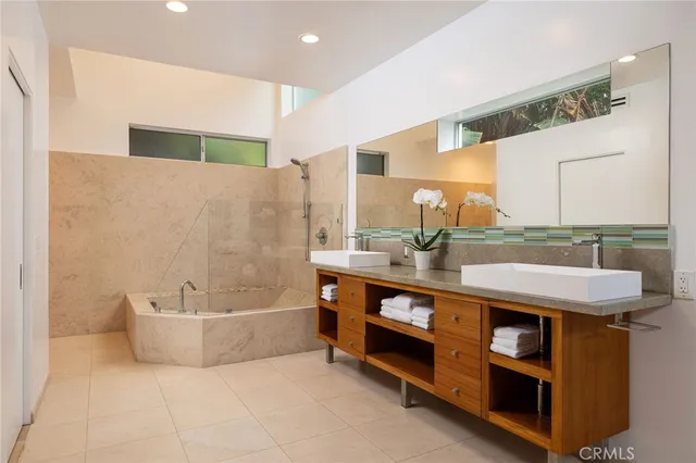 a spacious bathroom with a granite countertop sink a mirror and a bathtub