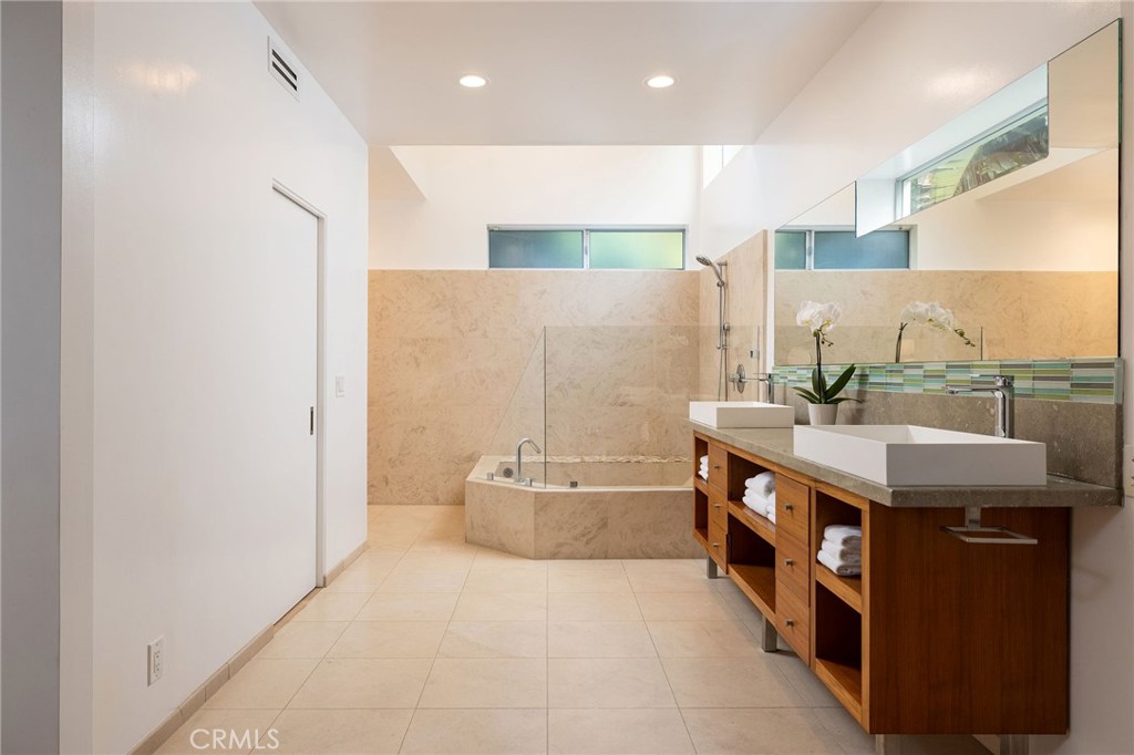 865 Balboa Avenue Laguna Beach, CA 92651 - Photo 18 of 60 a spacious bathroom with a granite countertop sink a mirror and a bathtub