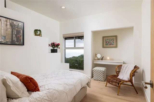 a bedroom with a bed lamp and a large window