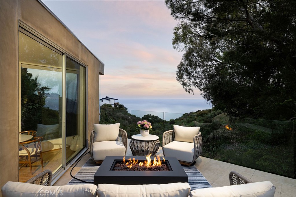 865 Balboa Avenue Laguna Beach, CA 92651 - Photo 31 of 60 a view of a patio with couches potted plants and a large tree