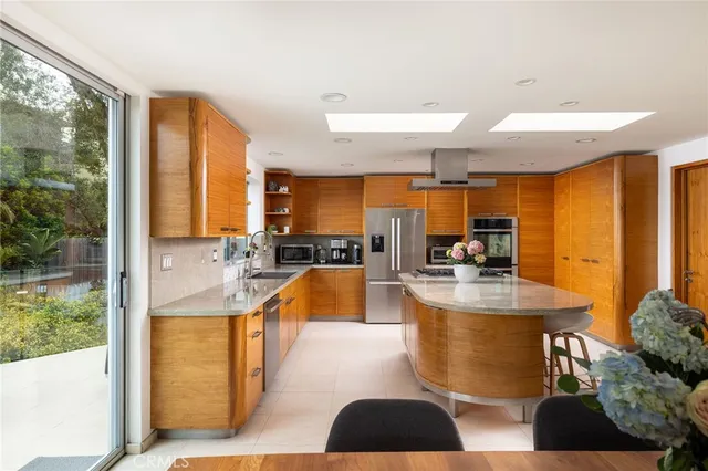a large kitchen with kitchen island a large window in it