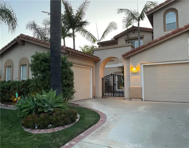 a view of a house with a small yard plants and palm trees