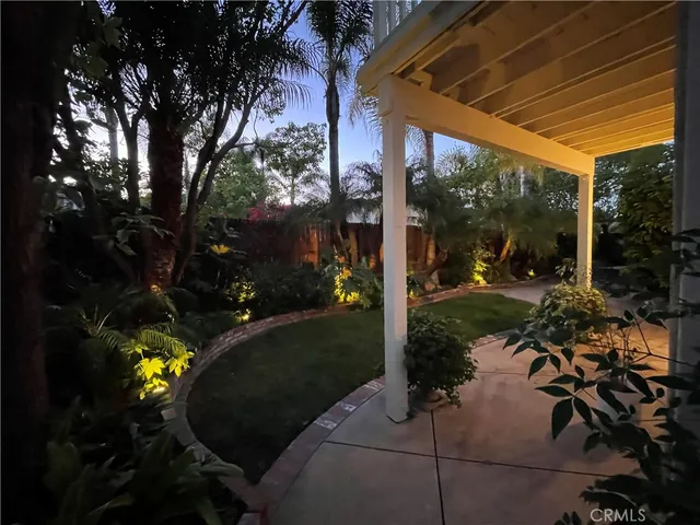 a backyard of a house with garden fountain and outdoor seating