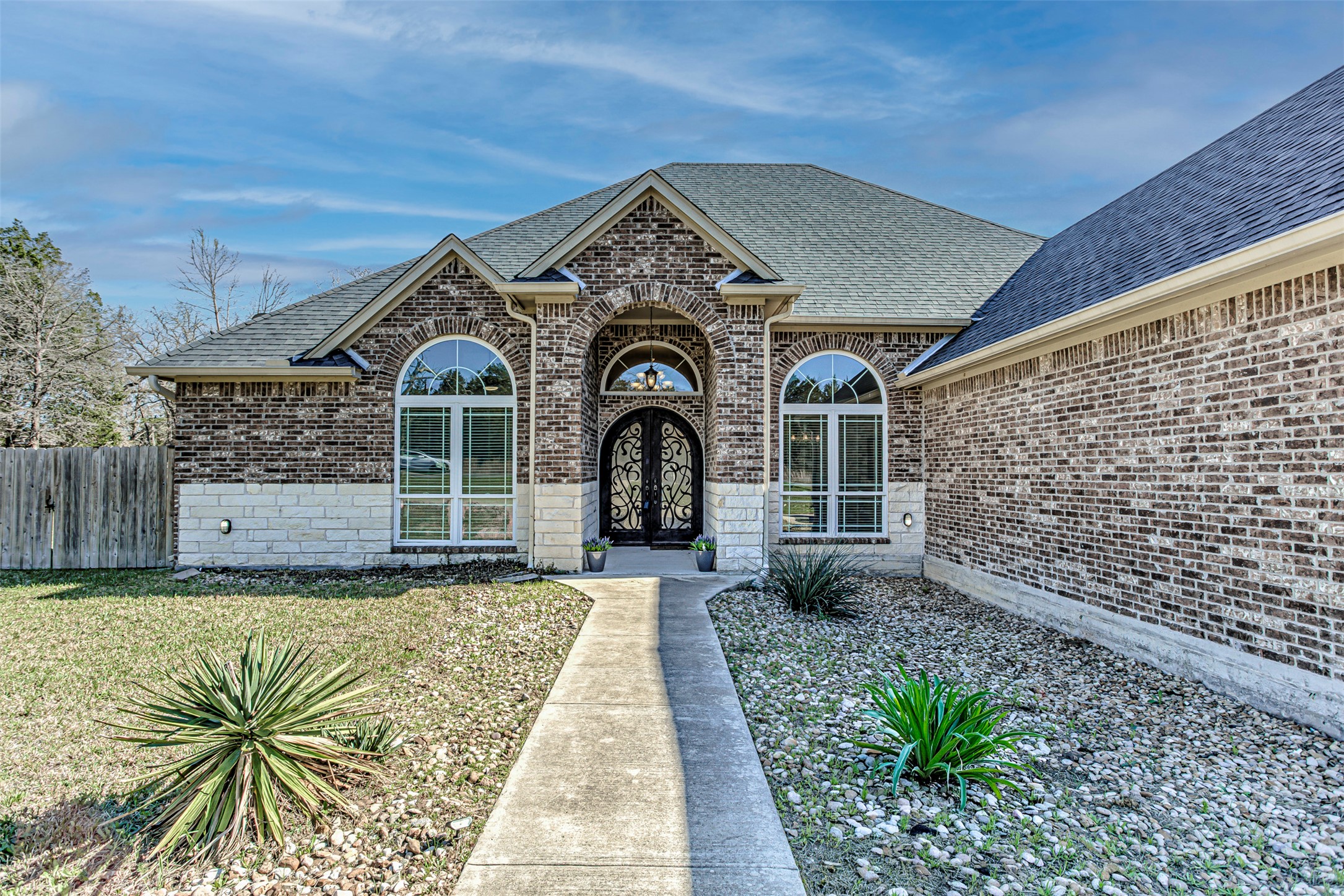 Entrance to property featuring a shingled roof and brick siding