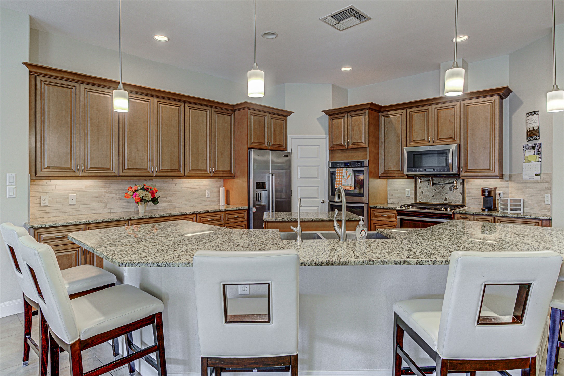 105 Arbors Circle Elgin, TX 78621 - Photo 13 of 40 Kitchen with wood finish cabinetry, pendant lighting, a kitchen bar, and stainless steel appliances