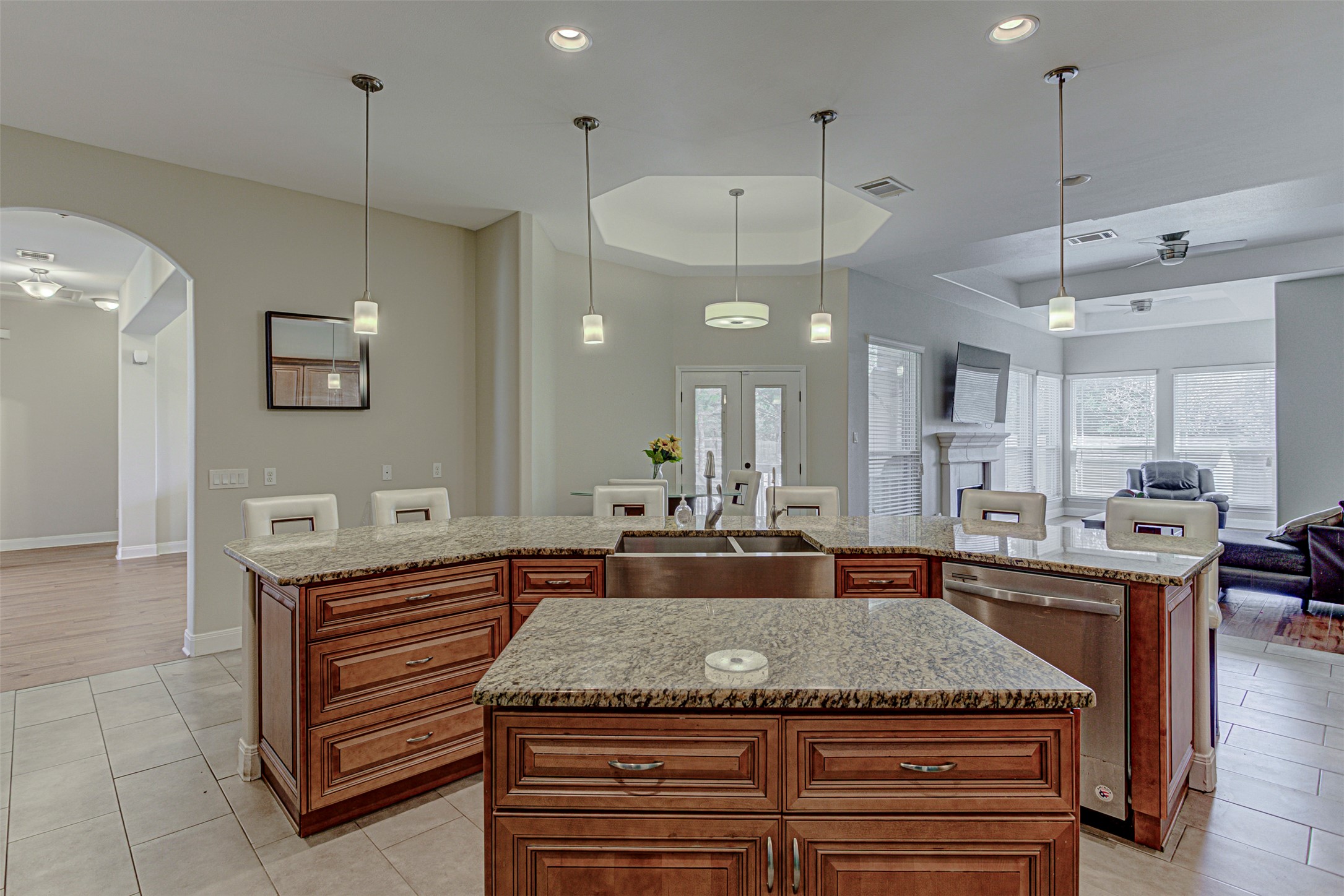 105 Arbors Circle Elgin, TX 78621 - Photo 39 of 40 Kitchen with a raised ceiling, open floor plan, light stone countertops, wood finish cabinetry, and stainless steel dishwasher